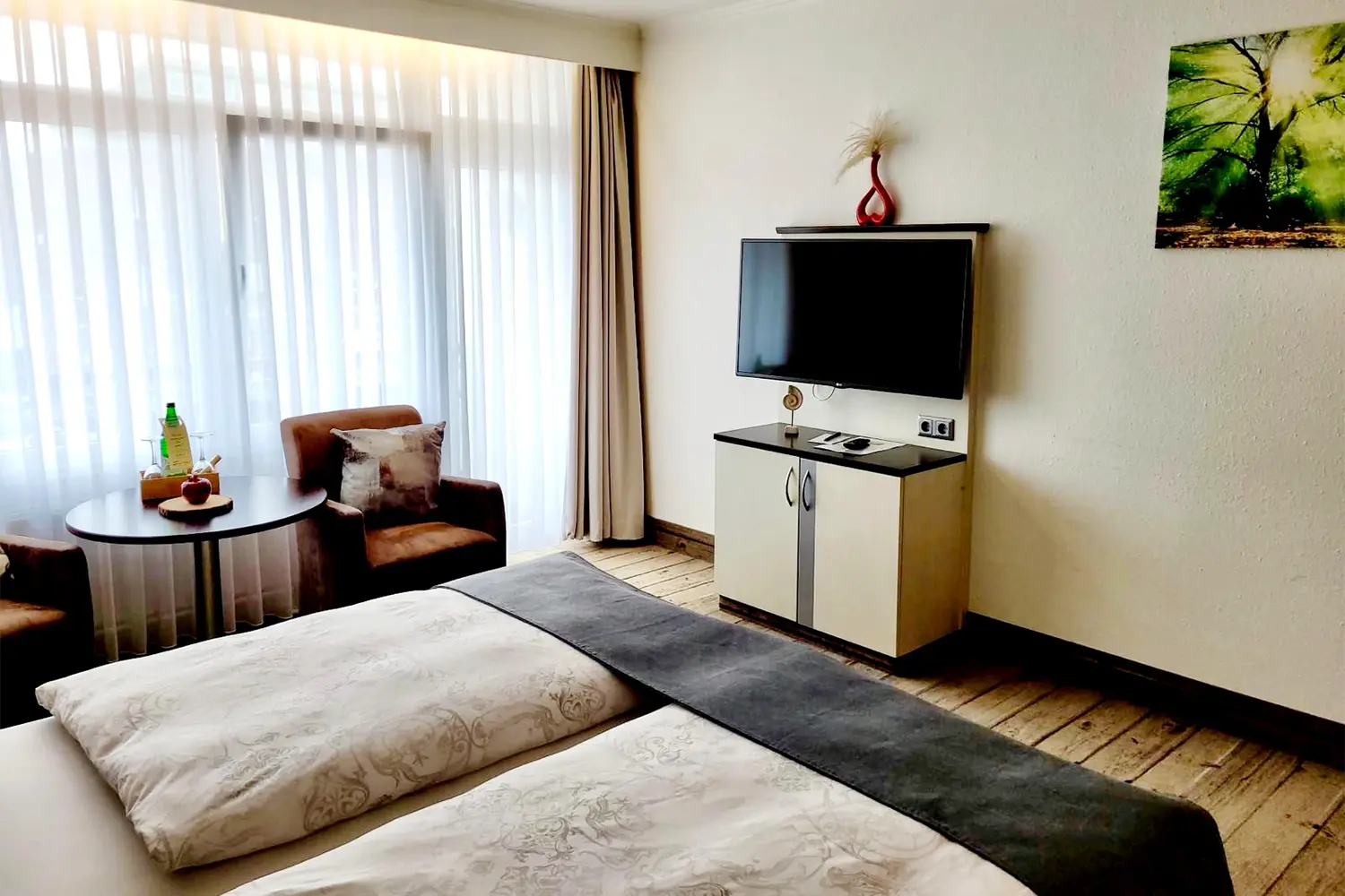 Doppelbett mit Hocker und TV im Familienzimmer für 3 Personen